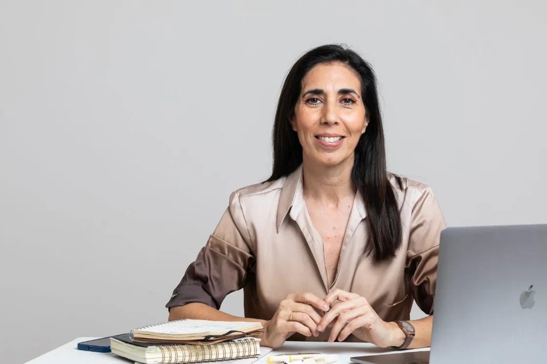 Irupé Franco sentada en su escritorio con la notebook y sus cuadernos