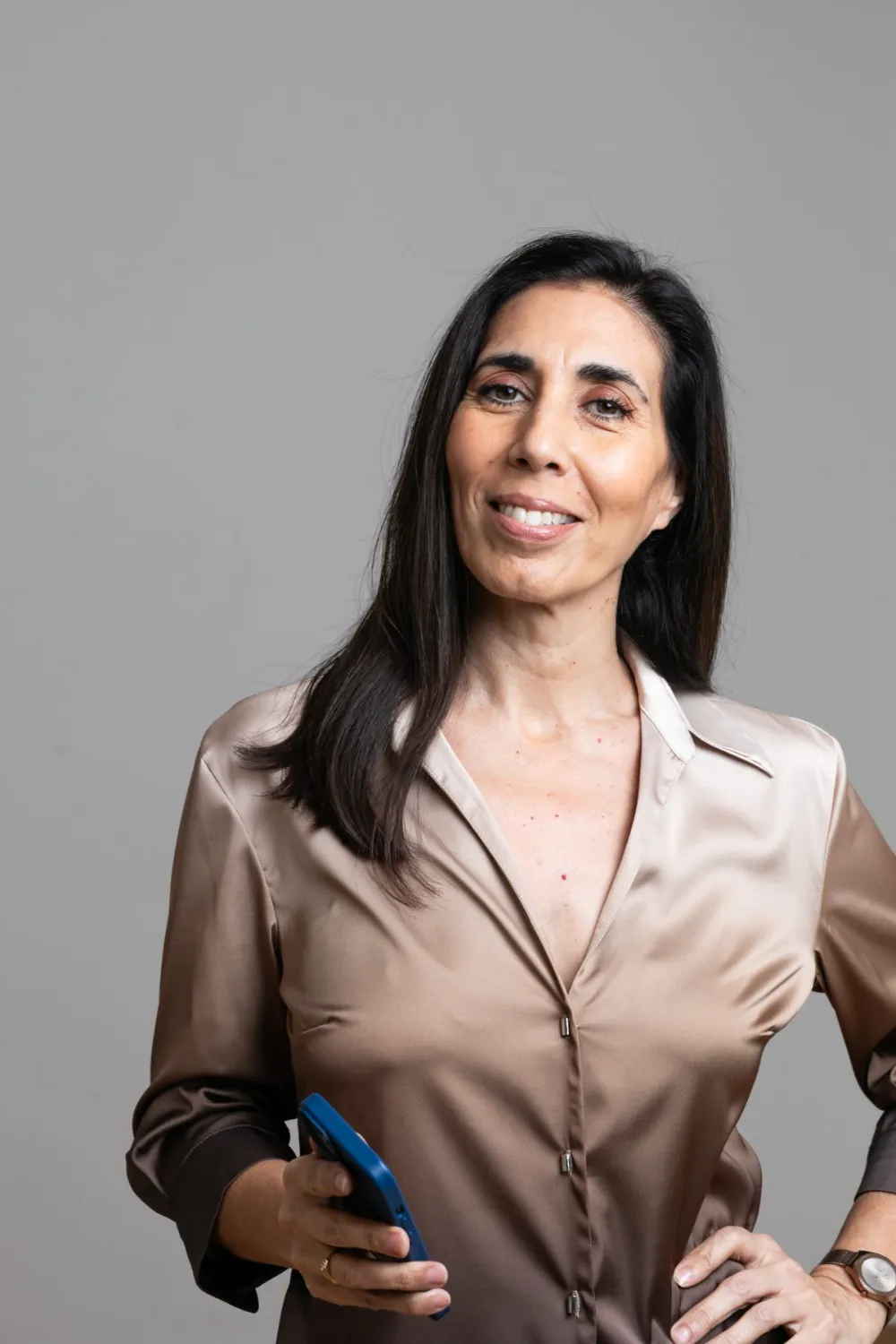 Irupé Franco, consultora de experiencia del cliente, con su celular en la mano